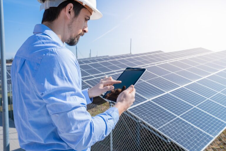 Engineer working with a tablet with photovoltaic solar panel system plant.